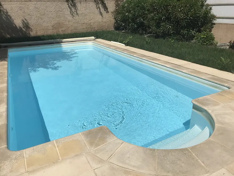 Piscine enterrée d’un particulier, entourée de margelles et d’une plage dallée