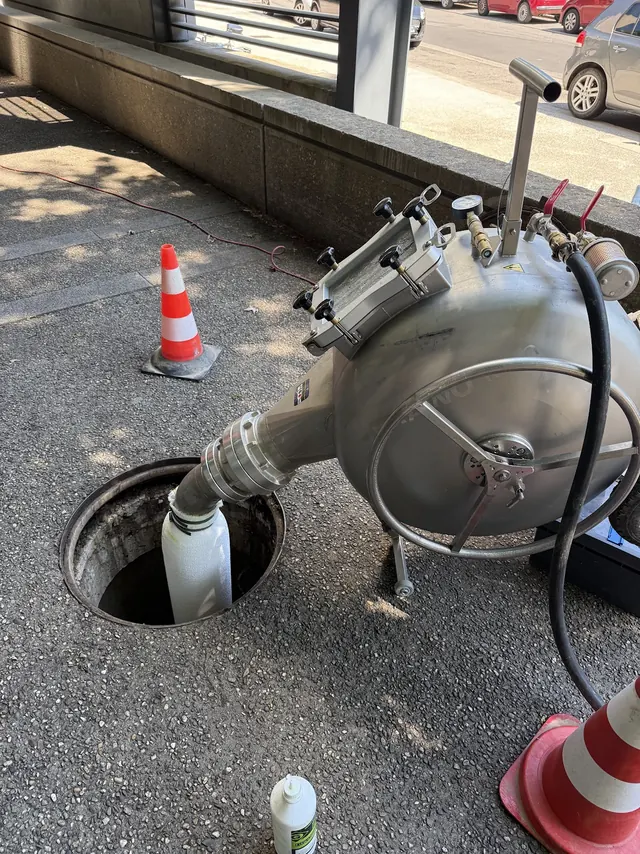 Machine de chemisage installée au-dessus d’un regard ouvert, sur une chaussée